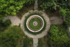 Overgrown circular fountain in a park, aerial view. photo