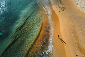 Aerial view of person walking on sandy beach, ocean waves. photo