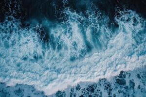 Aerial view of ocean waves crashing on shore. photo