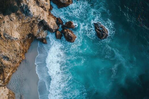 Aerial view of ocean waves crashing on rocky shore. photo