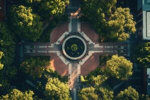 Aerial view of a city park with a circular fountain and surrounding trees. photo