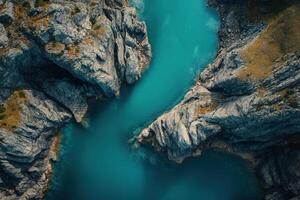 Aerial view of turquoise water flowing between rocky formations. photo