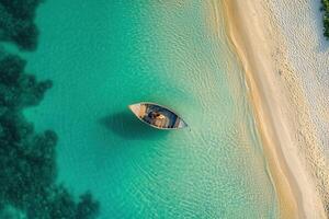 Aerial view of a small boat in turquoise water near a sandy beach. photo