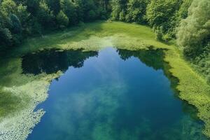 Aerial view of a serene, secluded lake surrounded by lush green vegetation. photo