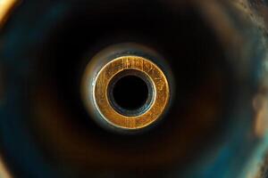 Close-up of a brass cylindrical object with a central hole, showing texture and detail. photo