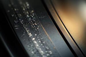 Close-up of condensation on a dark metallic surface. photo