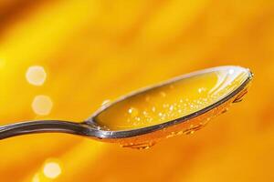 Close-up of honey on a spoon against a blurred yellow background. photo