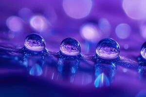 Macro shot of three water droplets on a purple surface with bokeh background. photo