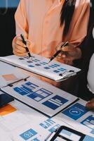Young Asian business creative team work together, mobile application software design project. Brainstorm meeting, internet technology, smartphone web app designer, office coworker teamwork concept photo