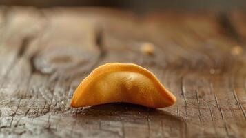 A single piece of fried dough on a wooden surface photo