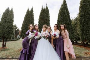 A group of women are posing for a picture in front of a tree photo