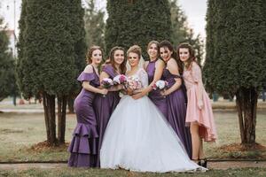 A group of women are posing for a picture in front of trees photo