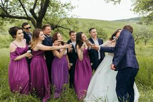 A group of people are gathered in a field, with a bride and groom in the center photo