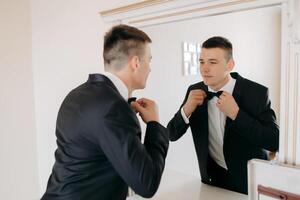 A man in a suit is getting ready to tie his tie photo