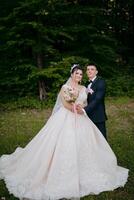 A bride and groom are posing for a picture in a forest photo