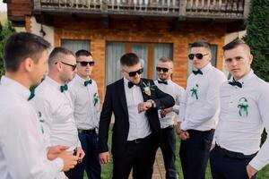 A group of men are standing in a circle, one of them wearing a watch photo