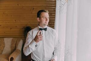 A man in a suit and tie is getting ready to go out photo
