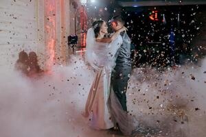 A bride and groom are dancing in the air with confetti falling around them photo