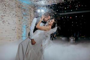 A bride and groom are dancing in the air with confetti falling around them photo