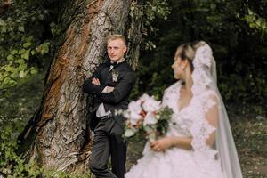 A man and a woman are standing in front of a tree photo