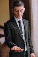 A man in a suit holding a ring in his hand photo