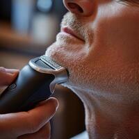 A close-up of a man being shaved with an electric razor in a modern barbershop photo