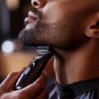 man being shaved with an electric razor in a modern barbershop photo