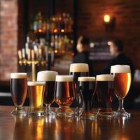 Various types of beer in different shaped glasses placed on a bar counter photo