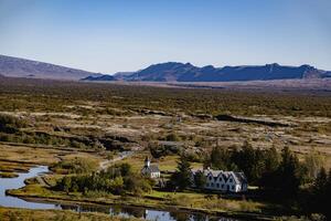 Iceland views. A large, empty desert with a small house in the middle photo