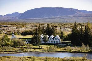 Iceland views. A small town with a church and a house sits in the middle of a large photo