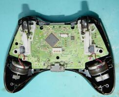 A game controller with wires and a circuit board photo