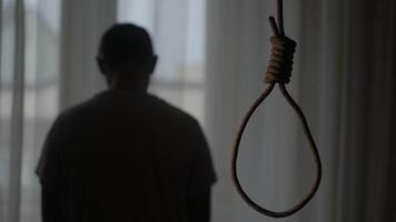 uma corda laço trava dentro uma Sombrio apartamento. a homem é depressivo e chateado. ele é contemplando suicídio. a conceito do personalidade crise. video