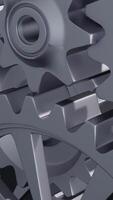 A close-up perspective showcases a series of rotating interlocking metal gears, highlighting the precise engineering and the complexity of mechanical design in machinery. vertical footage video