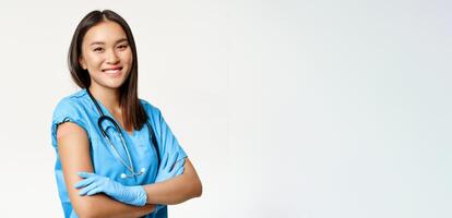 Smiling nurse, healthcare worker cross arms on chest, showing arm with patch, use vaccine shot from covid-19, standing over white background photo