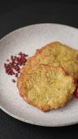 Delicious fried pork or chicken chops breaded with salt and spices on a dark concrete background video