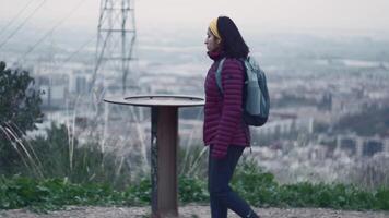 A woman leaves her village behind to climb to the lookout point and observe it from above. video