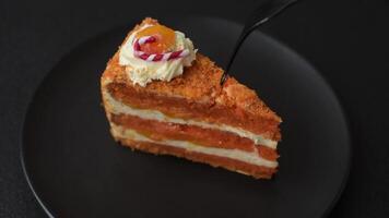 Piece of sweet layer cake with pumpkin or citrus flavor with cream on a dark textured background video