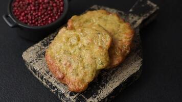 Delicious fried pork or chicken chops breaded with salt and spices on a dark concrete background video