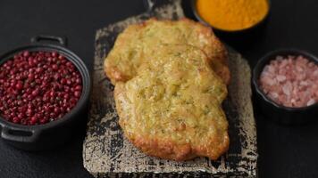 Delicious fried pork or chicken chops breaded with salt and spices on a dark concrete background video