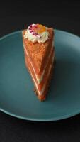 Piece of sweet layer cake with pumpkin or citrus flavor with cream on a dark textured background video