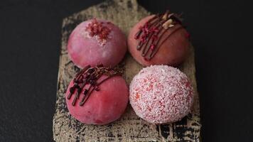 Delicious colorful asian mochi sweets with rice dough shell and fruit filling on dark concrete background video