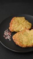 Delicious fried pork or chicken chops breaded with salt and spices on a dark concrete background video