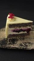 Piece of sweet layered cheesecake with cherries and poppy seeds on a dark textured background video