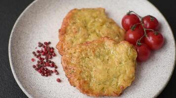 Delicious fried pork or chicken chops breaded with salt and spices on a dark concrete background video