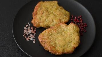Delicious fried pork or chicken chops breaded with salt and spices on a dark concrete background video