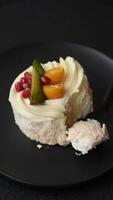 Piece of sweet meringue with citrus, kiwi and pomegranate seeds on a dark concrete background video
