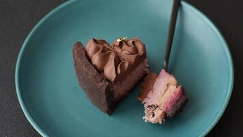 A piece of sweet cheesecake with mascarpone cheese, strawberry flavor, covered with chocolate on a dark concrete background video