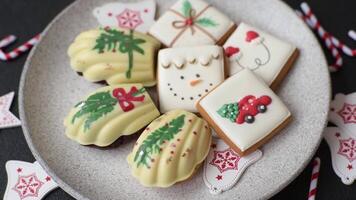 Sweet Madeleines desserts covered with chocolate in Christmas colors, with various toppings on a dark concrete background video