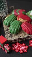 Sweet Madeleines desserts covered with chocolate in Christmas colors, with various toppings on a dark concrete background video