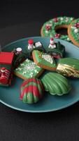 Sweet Madeleines desserts covered with chocolate in Christmas colors, with various toppings on a dark concrete background video